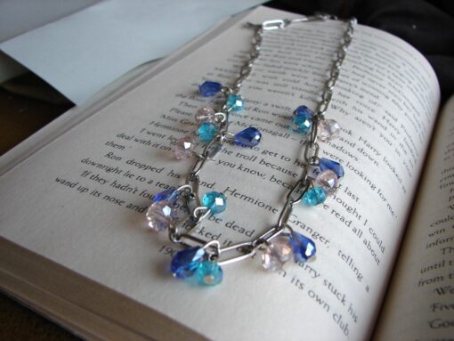 blue crystal necklace on book