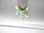 Close-up of Gulnaar pendant — natural jade spheres and freshwater pearl cluster with gold cube beads, handmade natural stone jewelry Pakistan Dango