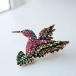 Dango 5x5cm vintage crystal hummingbird brooch made of alloy with multi-colored rhinestones, displayed flat on a clean surface, available in Pakistan.