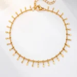Dango IP gold plated stainless steel anklet with dangling fringe charms laid flat with 21+5cm dimensions, available in Pakistan.