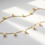 Dango 18K gold plated chain necklace with dangling freshwater pearls resting on a white background.
