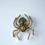 Dango 1.8x1.35 inches vintage green crystal spider brooch made of alloy with rhinestones, displayed flat on a clean surface, available in Pakistan.