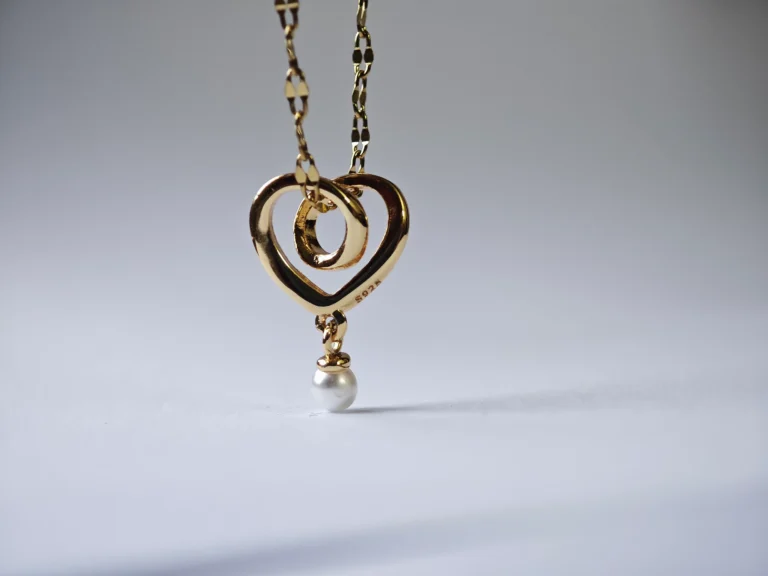 Dango gold plated stainless steel chain with a 10mm plated copper interlocking heart and pearl pendant, displayed against a clean background in Pakistan.