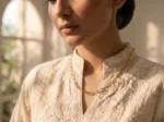 Model in Pakistan wearing the Dango gold plated stainless steel paperclip chain necklace alone against her neckline.