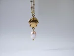 Dango gold plated stainless steel PVD chain with a 7mm seashell charm and dangling freshwater pearl, displayed against a clean background in Pakistan.