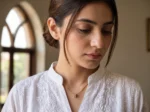 Model in Pakistan wearing the Dango gold plated PVD zircon wheel pendant necklace against her neckline.