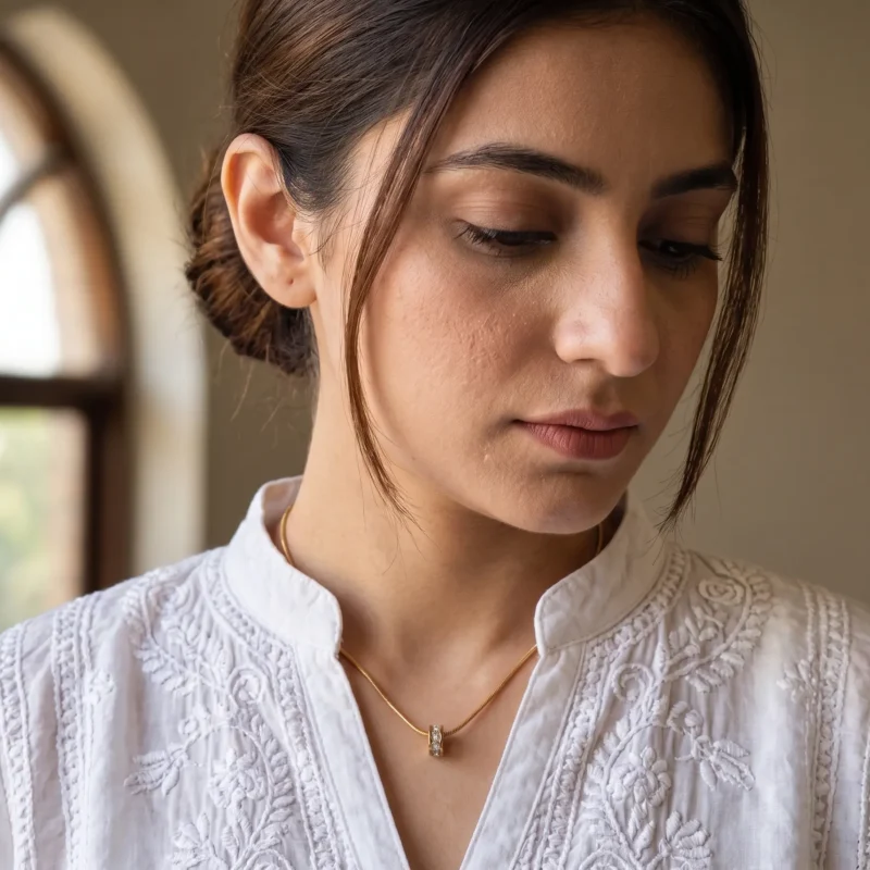 Model in Pakistan wearing the Dango gold plated PVD zircon wheel pendant necklace against her neckline.